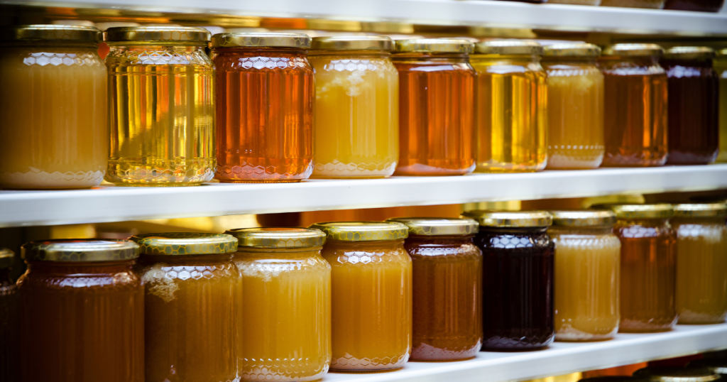 Different jars of honey on a shelf